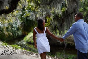 Bride and groom running together in a candid wedding portrait by The Palmetto Studios in New Orleans.